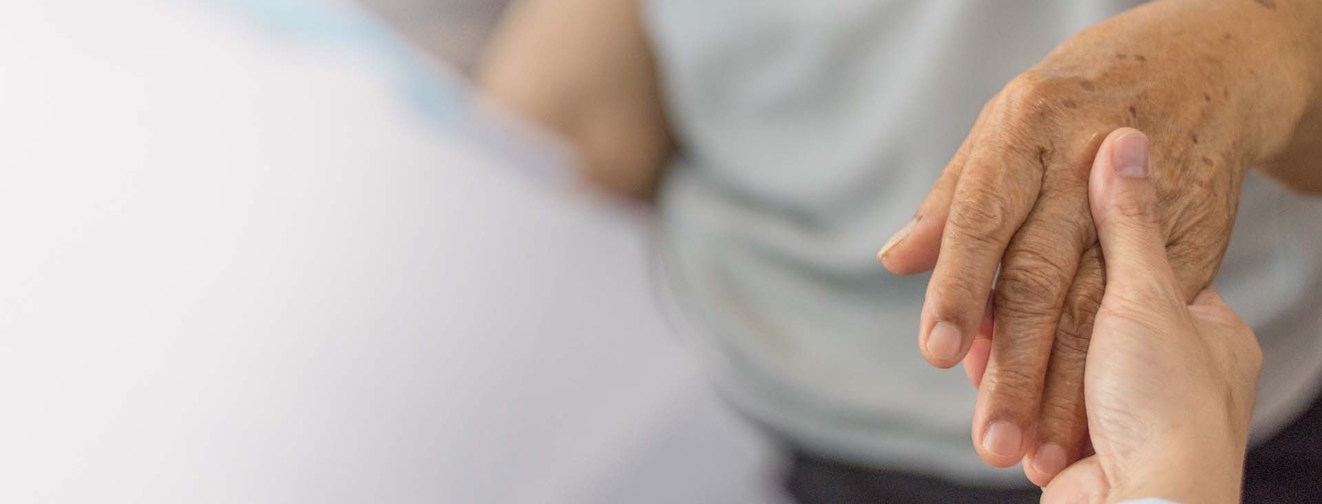 Older person's hand being held